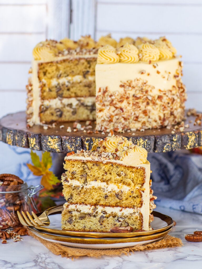 sliced maple pecan cake with diced pecans and buttercream frosting