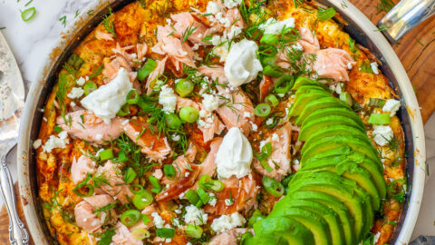 overhead view of salmon frittata in frying pan with toppings