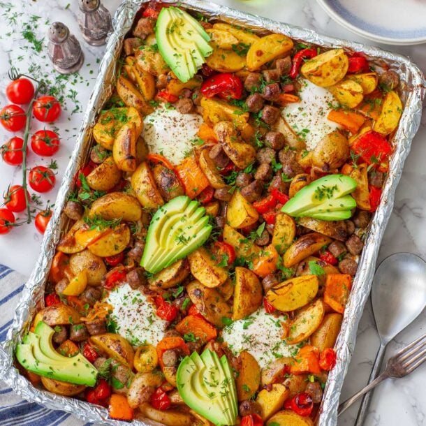 a sheet pan with breakfast potatoes, eggs and vegetables, on a table
