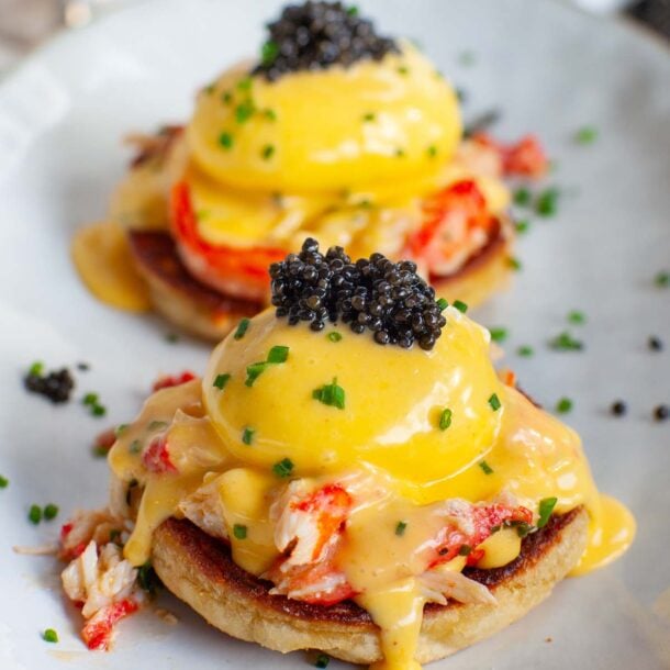 A closeup image of crab eggs benedict with caviar on a plate.