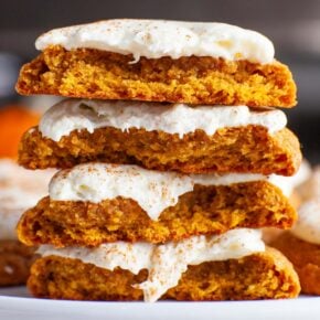 A closeup image of frosted pumpkin cookies cut open and stacked.