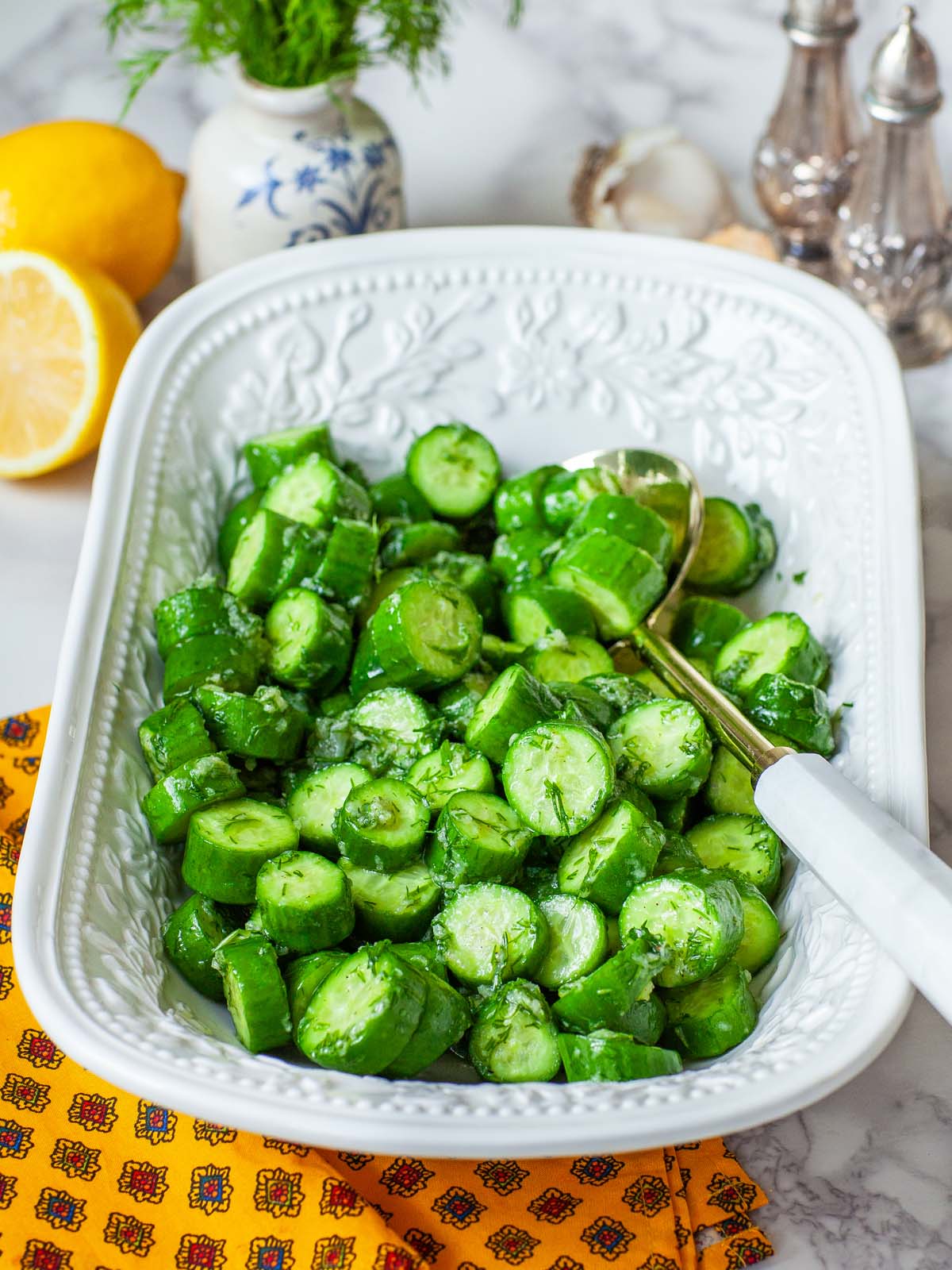 Chopped cucumber salad in a serving tray, with a large spoon.