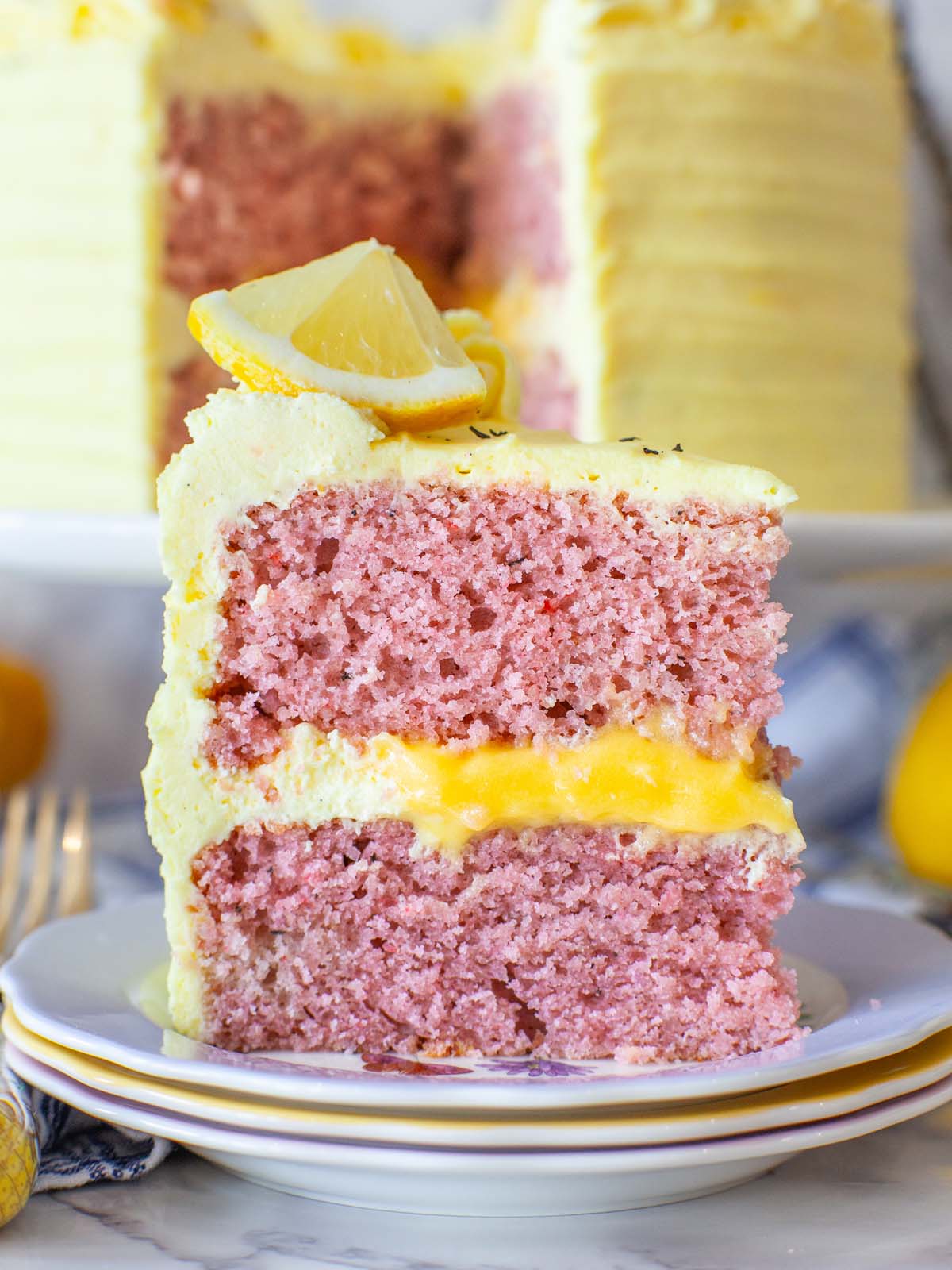 A closeup image of a slice of lavender cake with lemon curd filling.