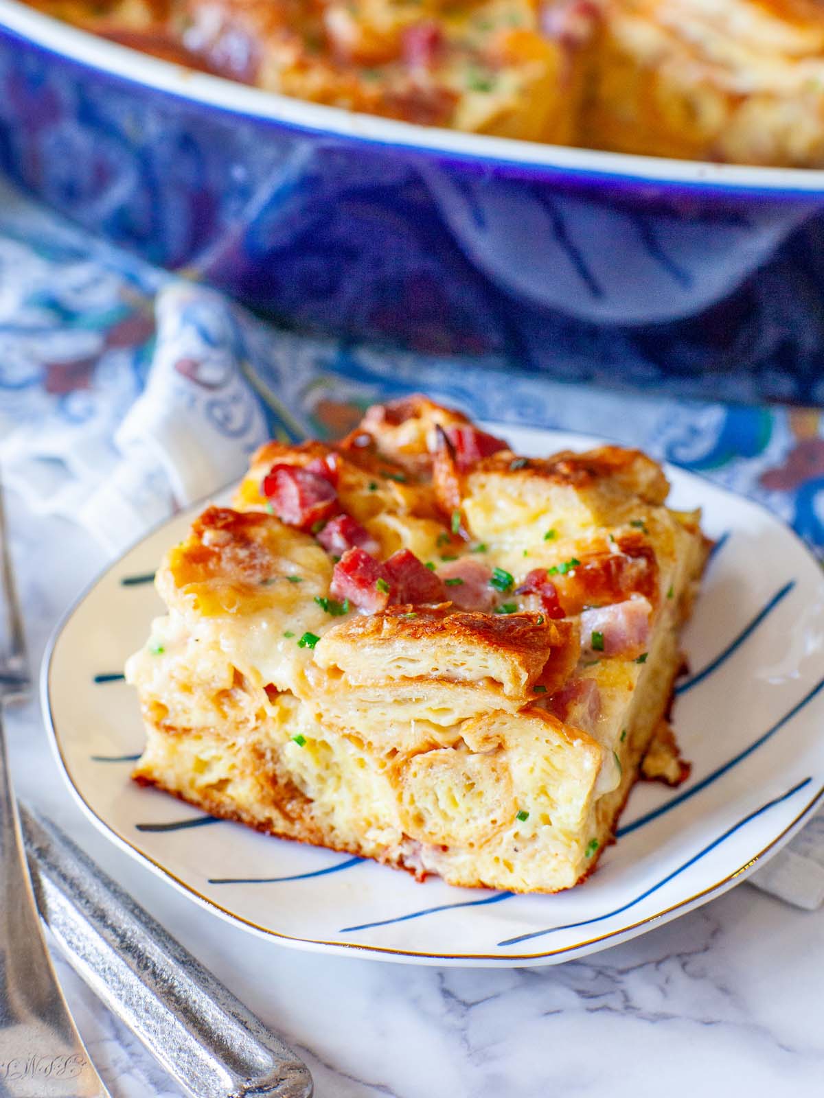 A closeup image of serving of ham croissant casserole on a plate.